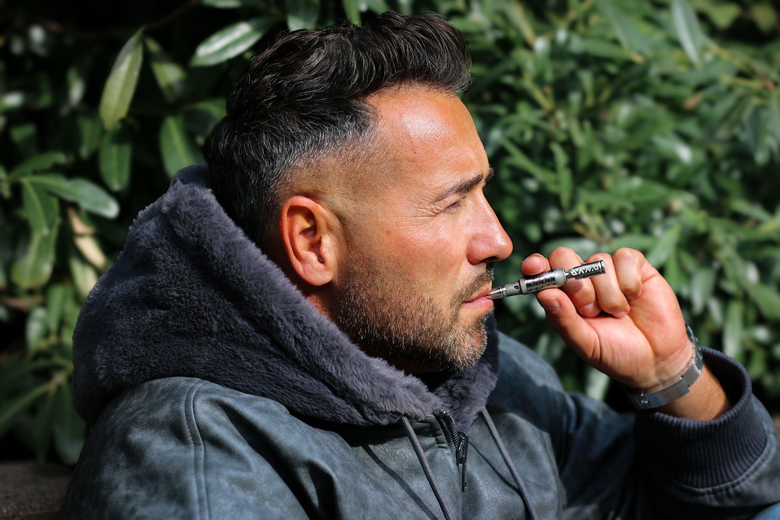Man vaping outdoors in warm jacket