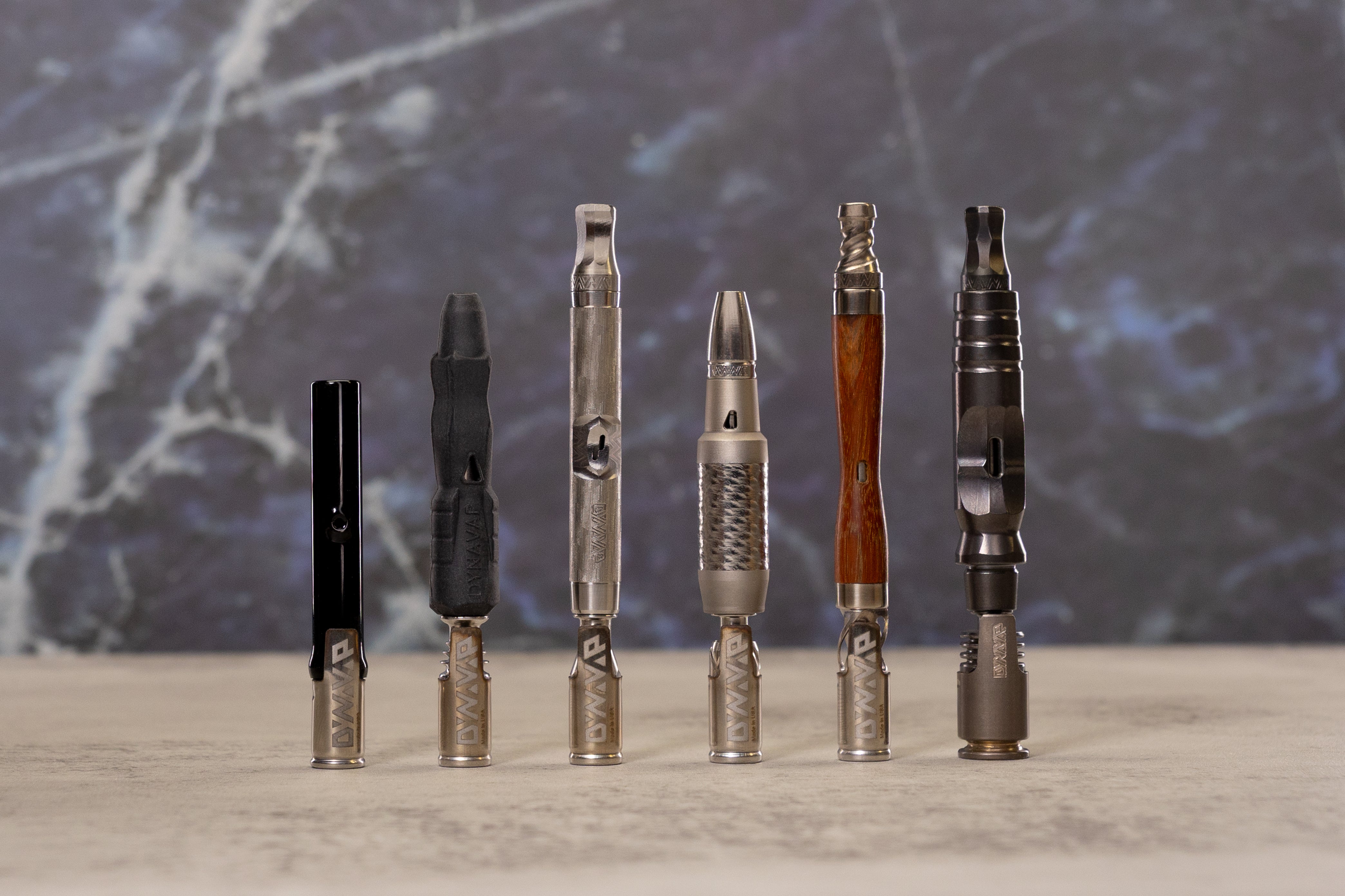 Assorted metal smoking devices on marble background