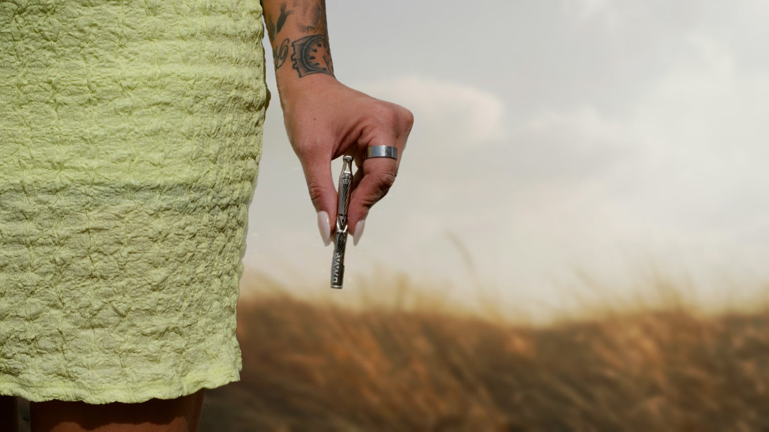 Tattooed hand holding car key outside