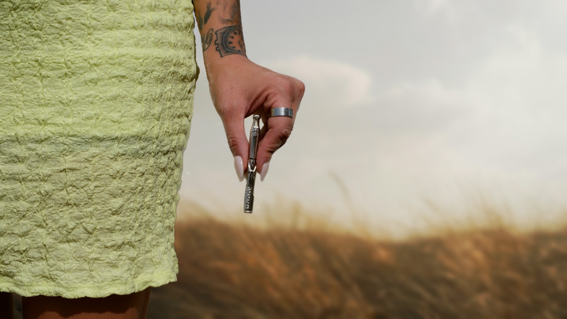 Tattooed hand holding car key outside